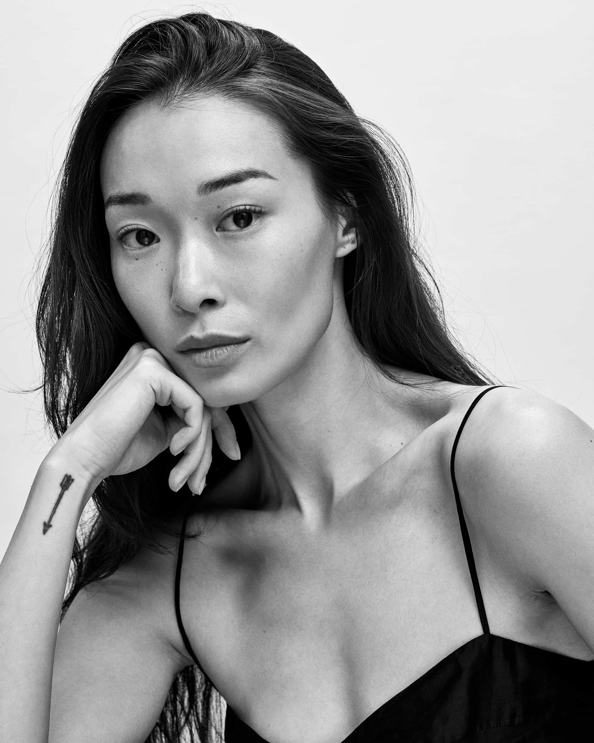 Black-and-white portrait of BIBI resting her chin on her hand